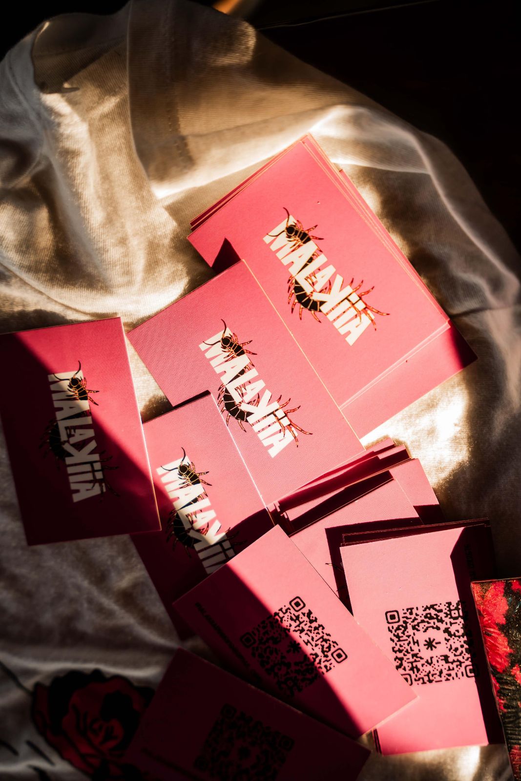 Volantini rosa MALAKIIA con logo a centopiedi e QR code
